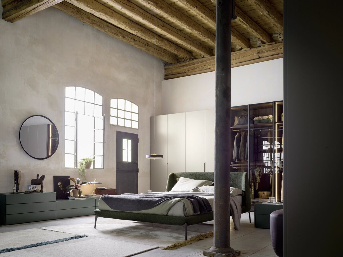 Schlafzimmer im Loft mit Polsterbett und offenem Kleiderschrank